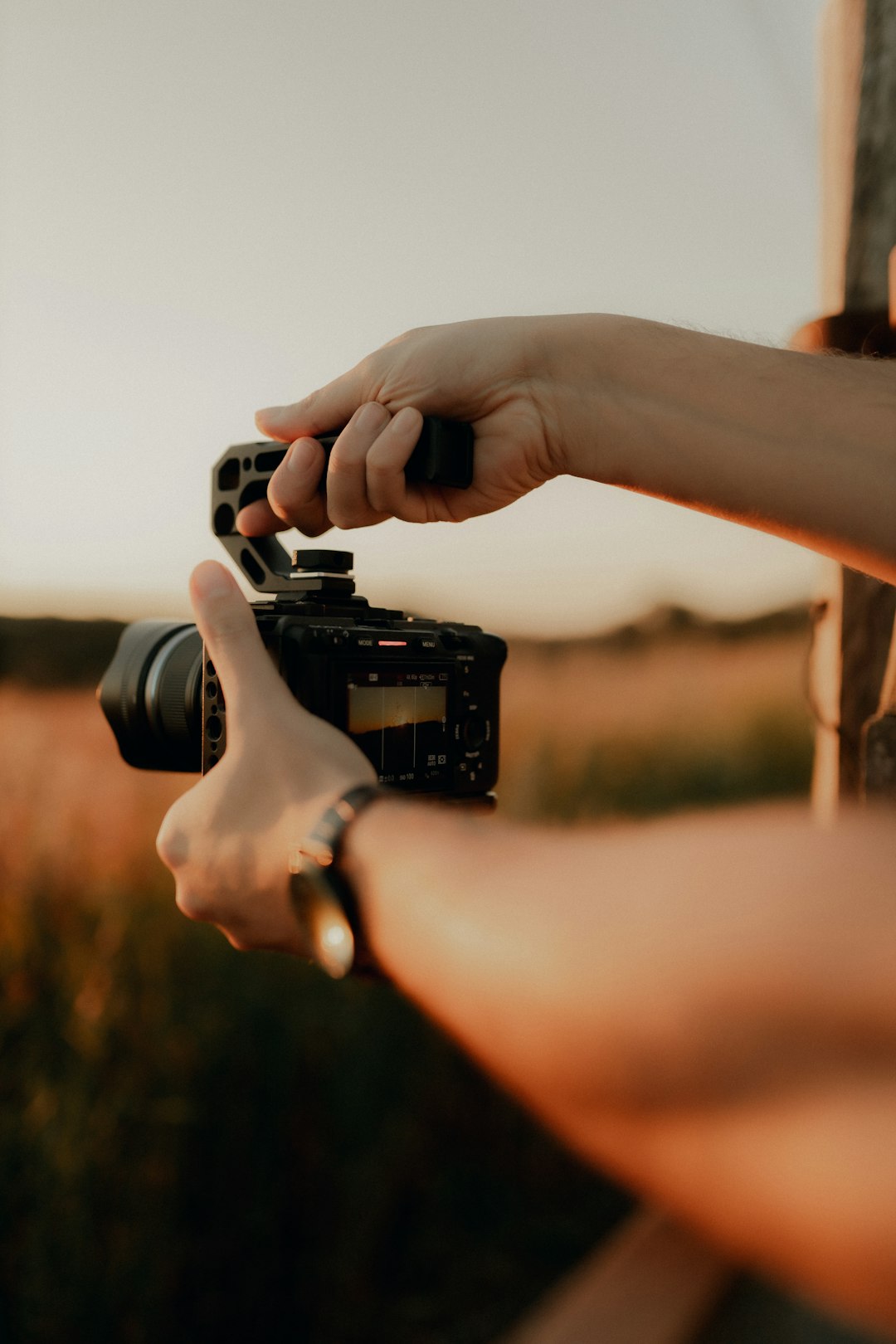 hands-holding-a-camera-with-a-handle-2h7fkwaivpu