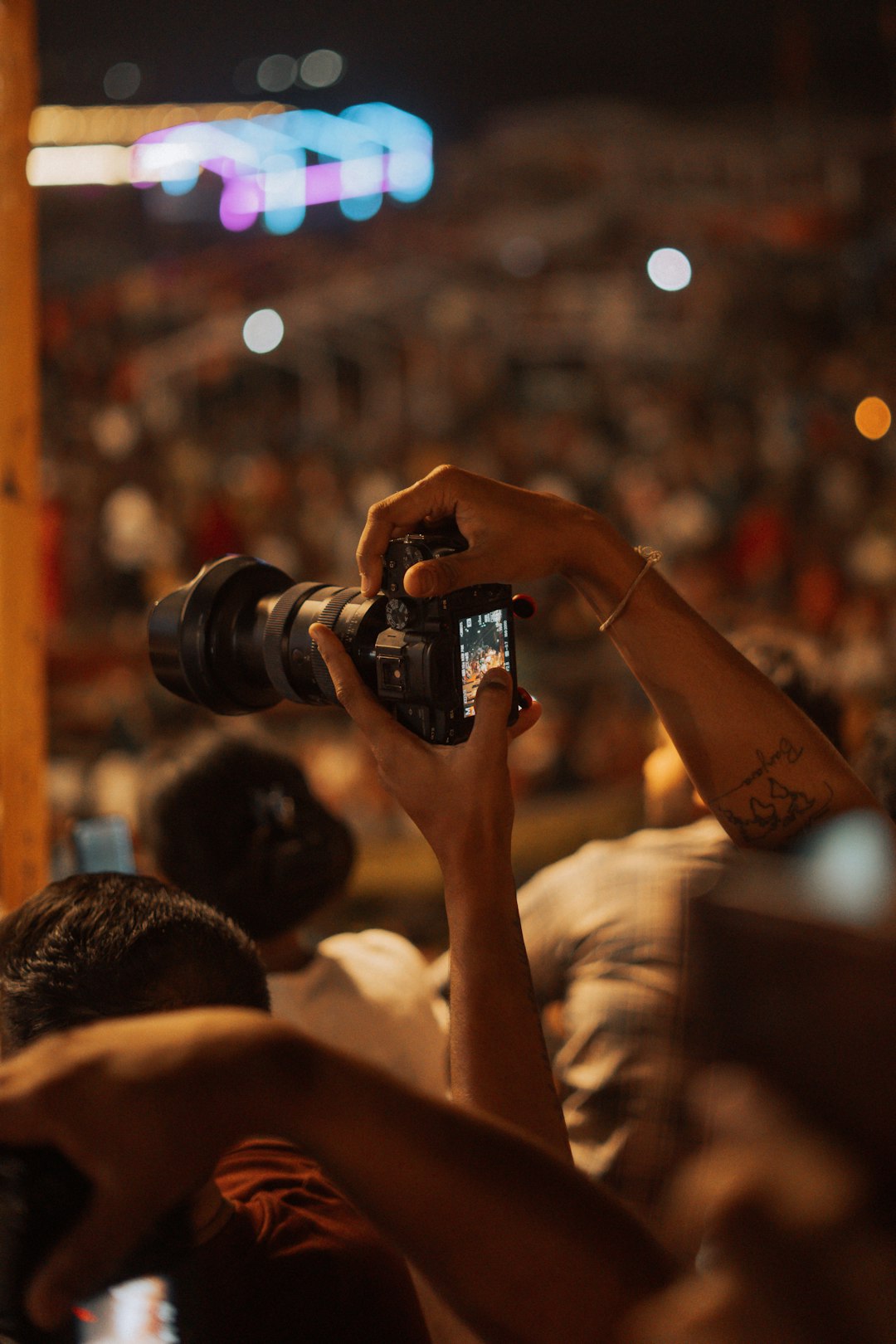 person-holding-camera-at-a-crowded-event-26wtd5v33c8
